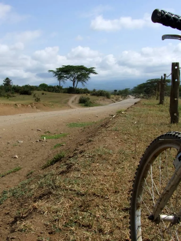 Cyclist riding through Hell's Gate National Park, Kenya — one of the few parks where bikes are permitted