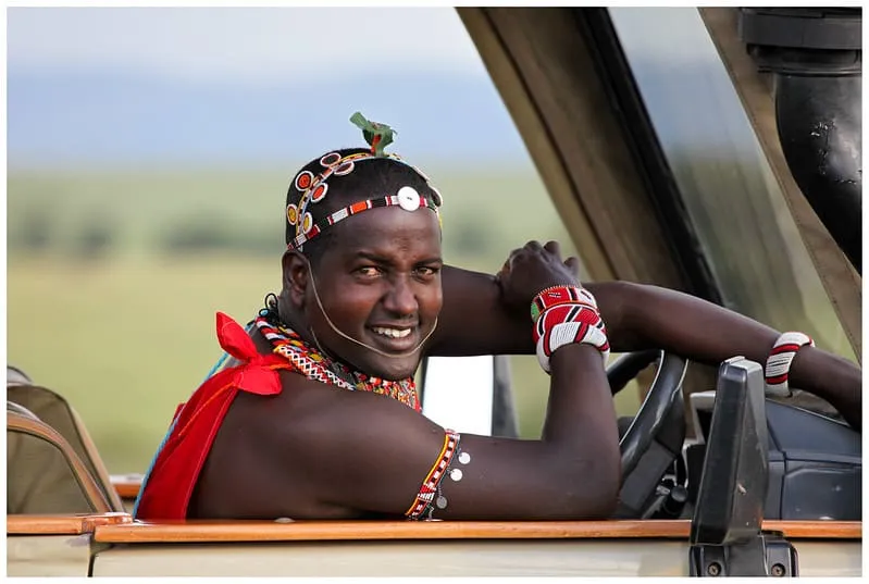 A Kenyan safari guide pointing out wildlife — guides are fluent in English and highly knowledgeable